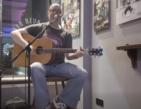 Barry from audioCue with an acoustic guitar preparing a setlist with backing tracks.