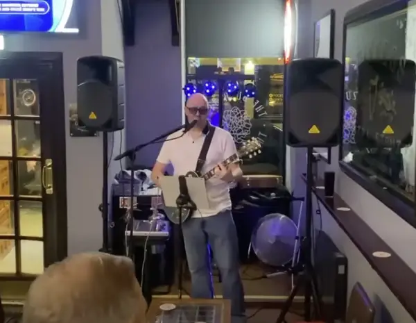 Solo musician performing a live set in a local pub using a tablet and backing tracks.